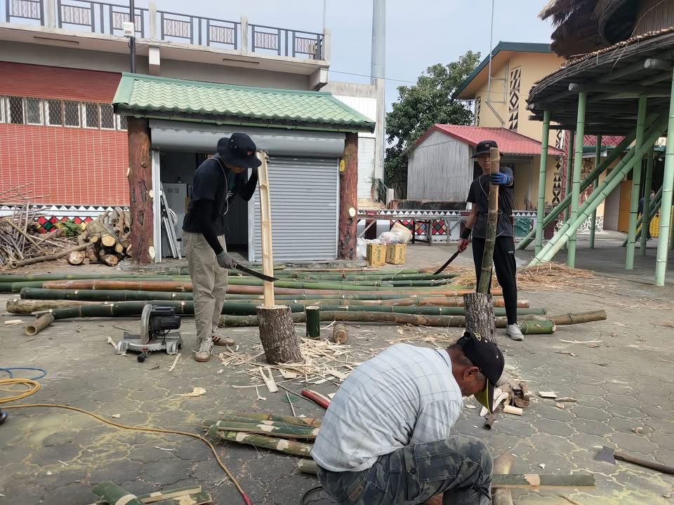 兩個年輕人在木頭上劈竹子